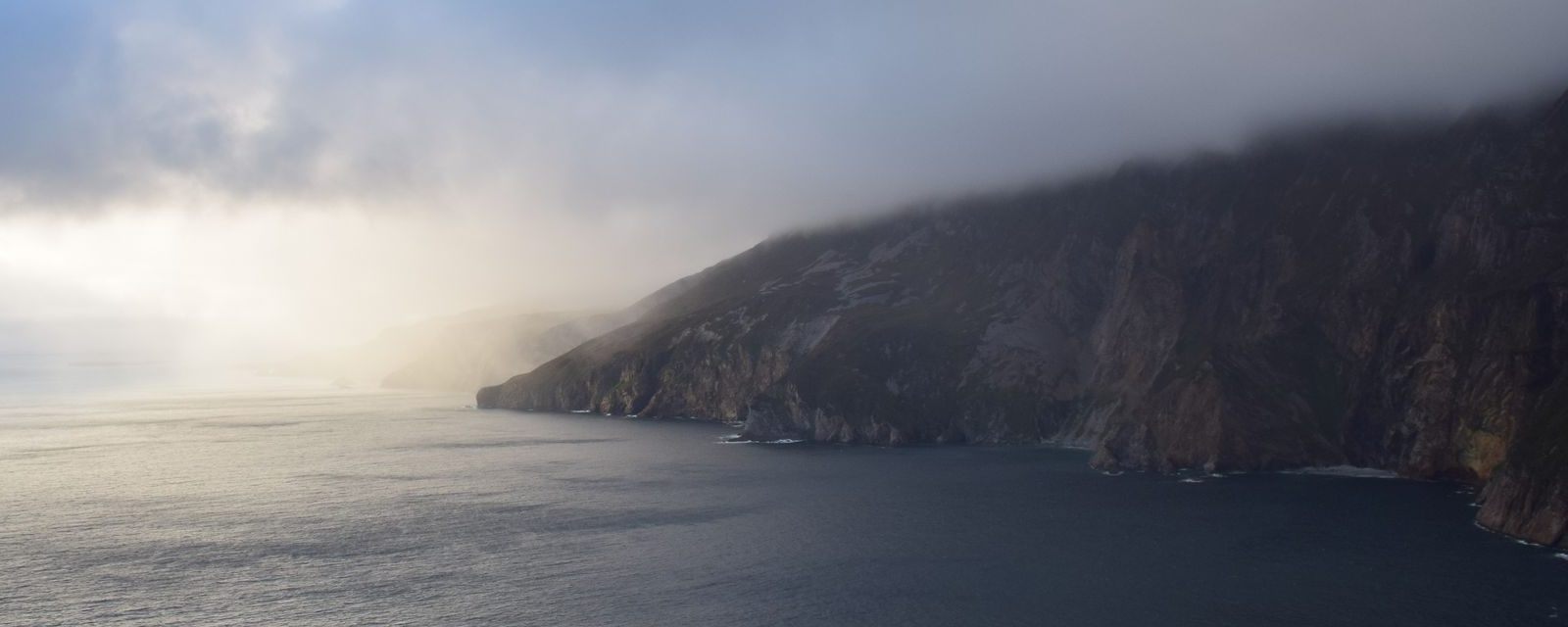 The sea cliffs of Slieve League in County Donegal under a cloudy sky